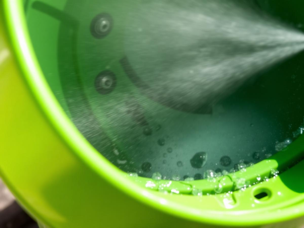 High pressure water jets steam cleaning the inside of a garbage can